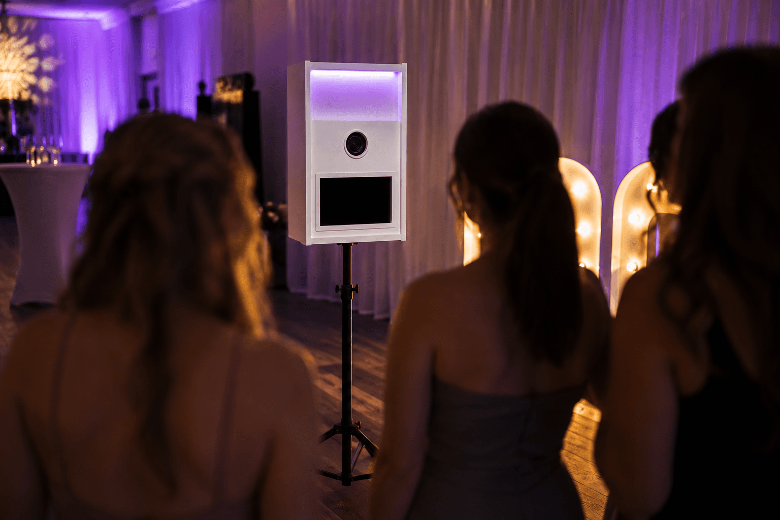 Eventgäste posieren und lachen an der weißen Premium Fotobox von DieFotoboxen.de